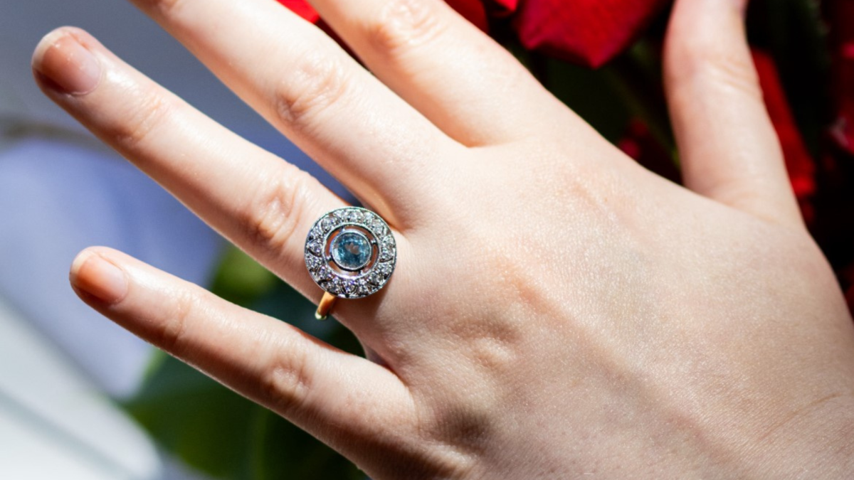 0.88-carat light blue aquamarine stone ring, surrounded by a halo of diamonds in a floral arrangement.