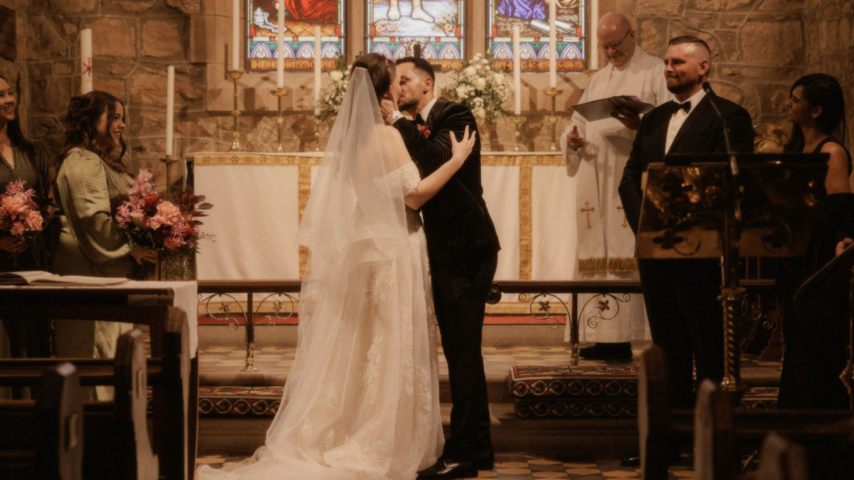 Cai and Holly Andrade kissing on their wedding day