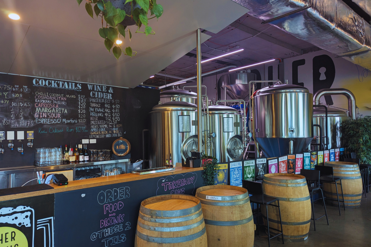 A bar with brewing vats in background.