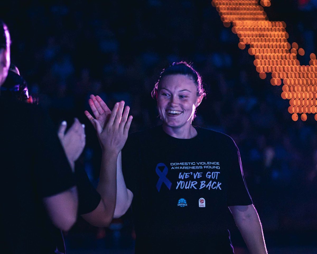 UC Capitals player Nicole Munger high-fiving a hand