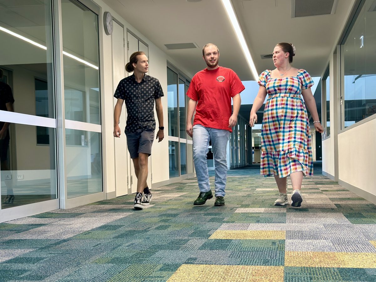 three people walking down a corridor