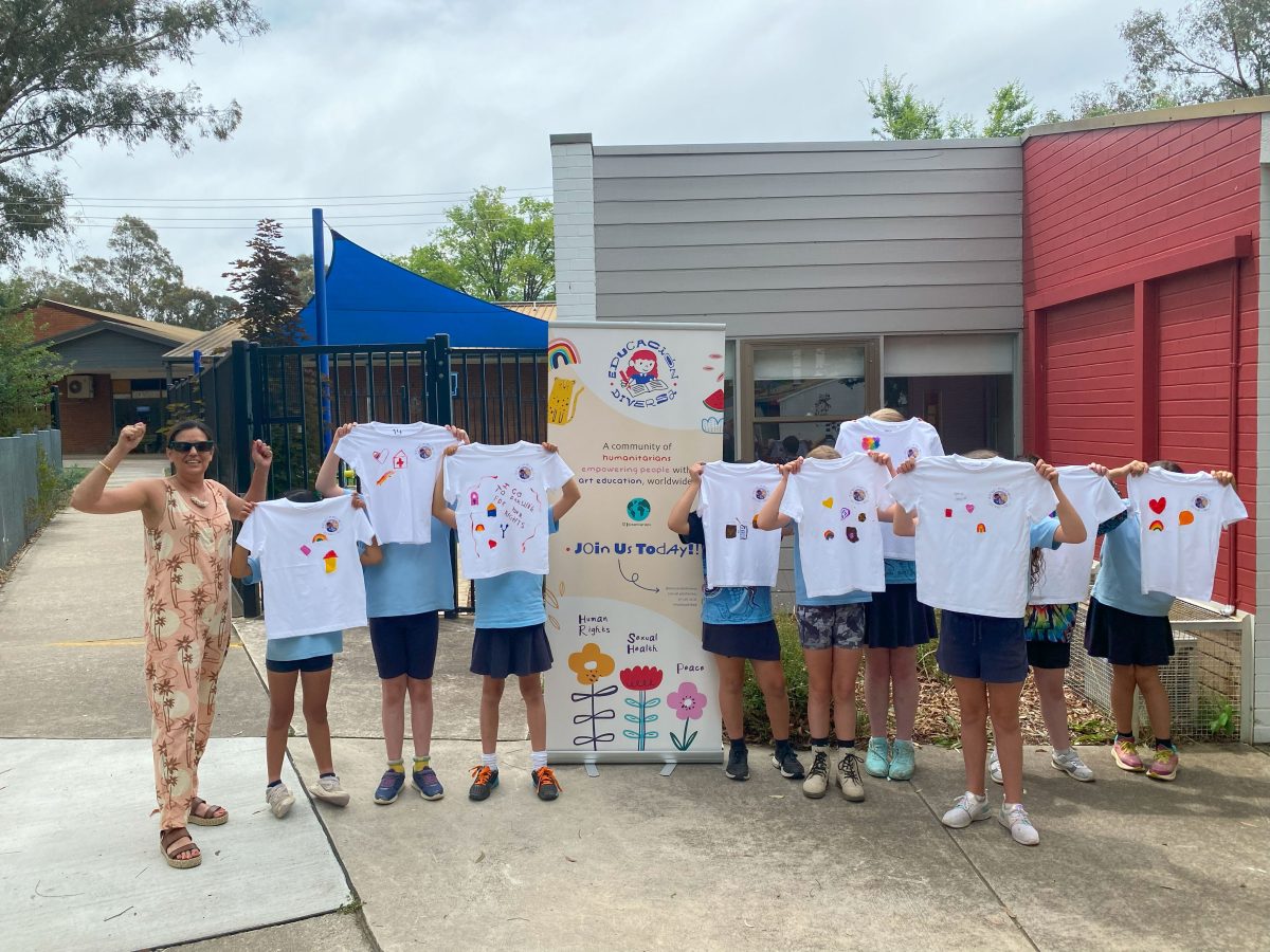 a woman with kids holding up T-shirts