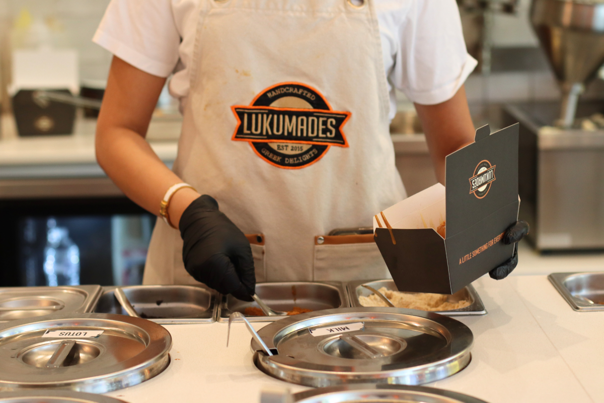 Lukumades being topped and filled.