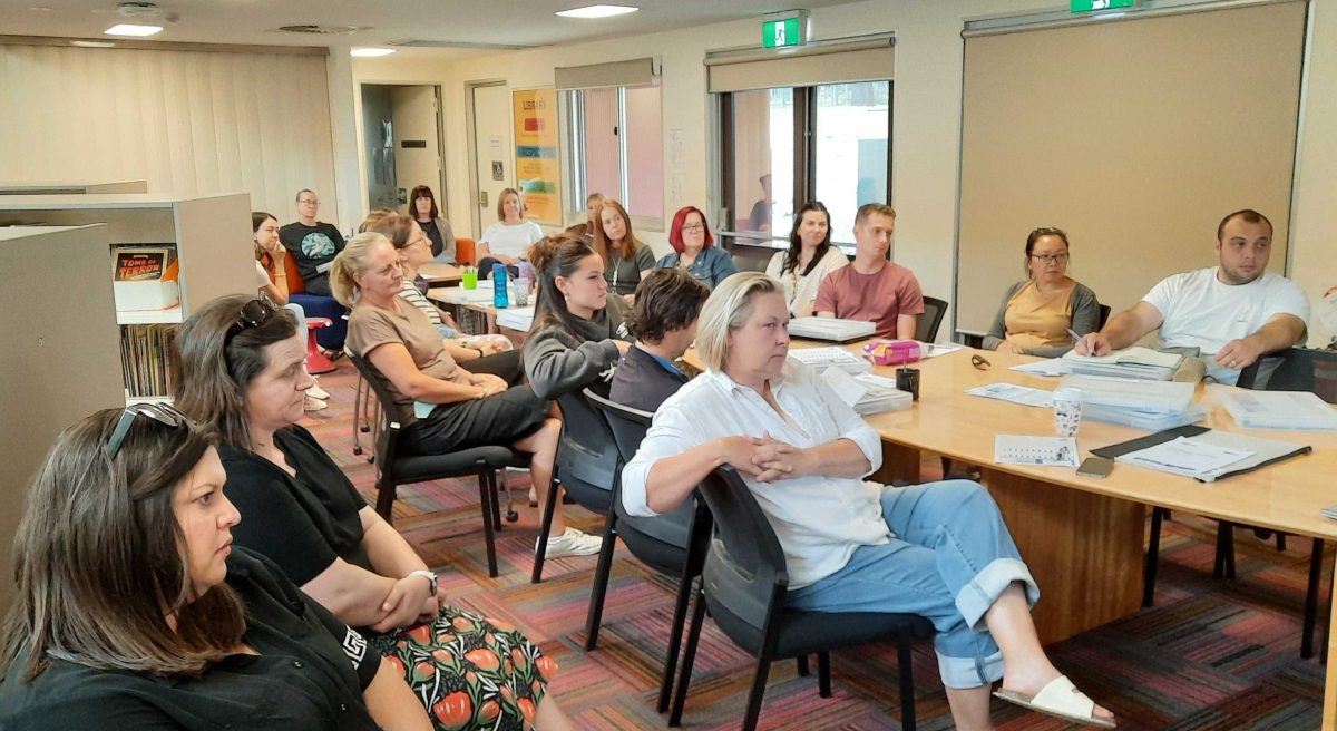 a group of people listening to a classroom presentation