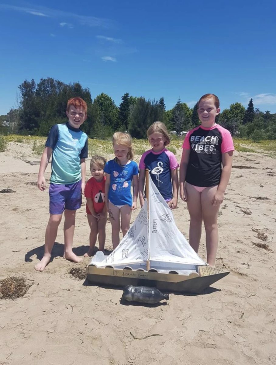 children standing near a small boat