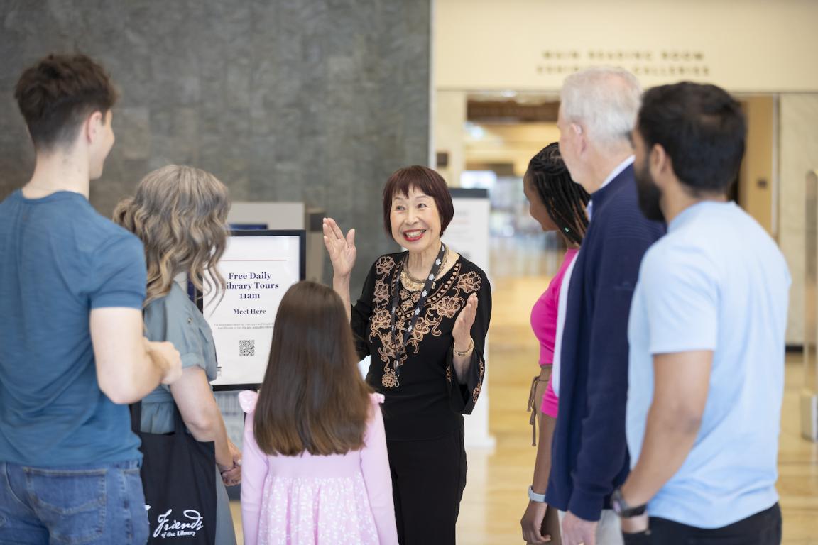 a group of people listening to a tour guide at the National Library of Australia