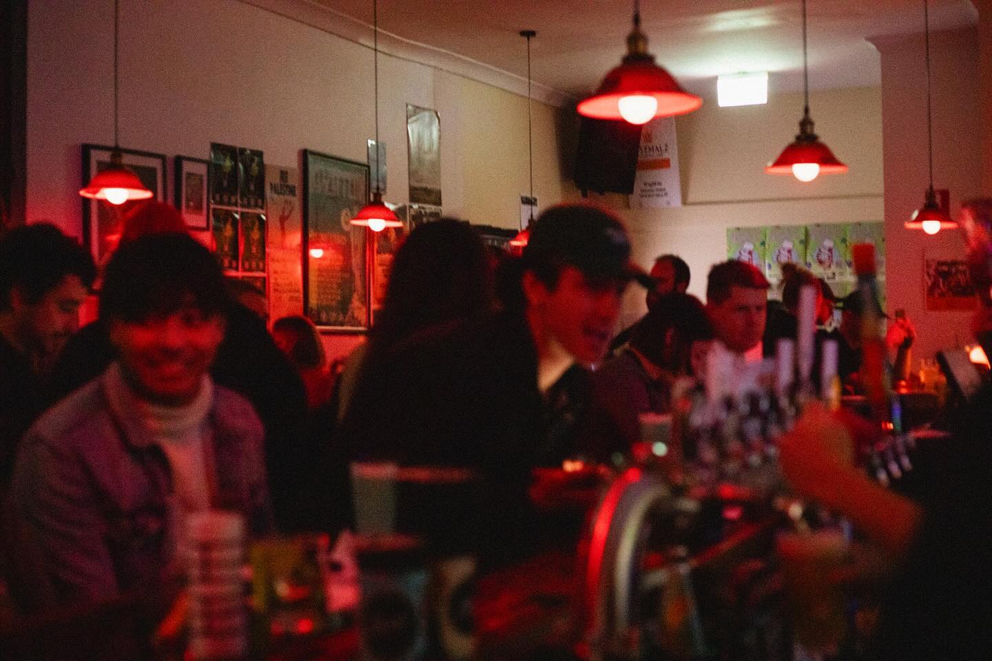 Interior of a dive bar with red swinging lights.