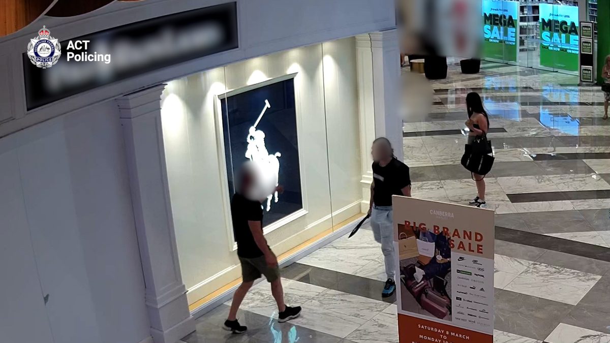 Three people inside a shopping centre, two with their faces blurred and one facing away from a camera