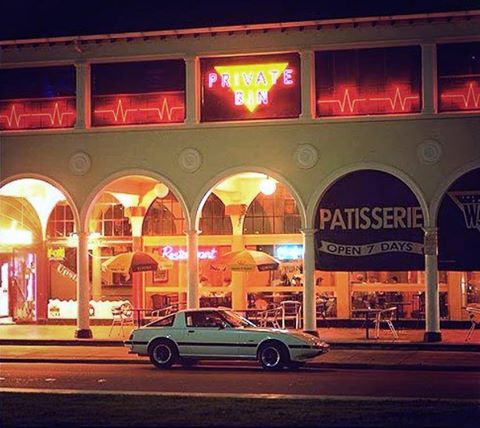 An old photo of the Sydney building at night featuring the Private Bin sign