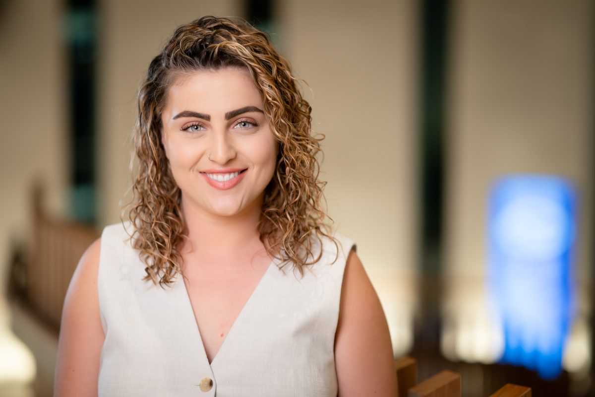 A woman with blonde curly hair smiling at the camera