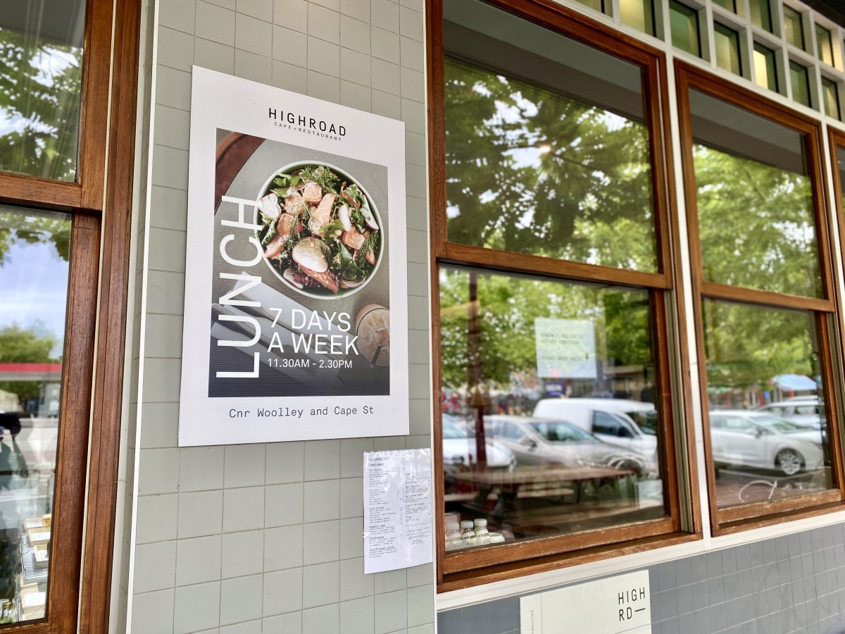 A poster reading LUNCH with a photo of a salmon salad on the exterior of a cafe