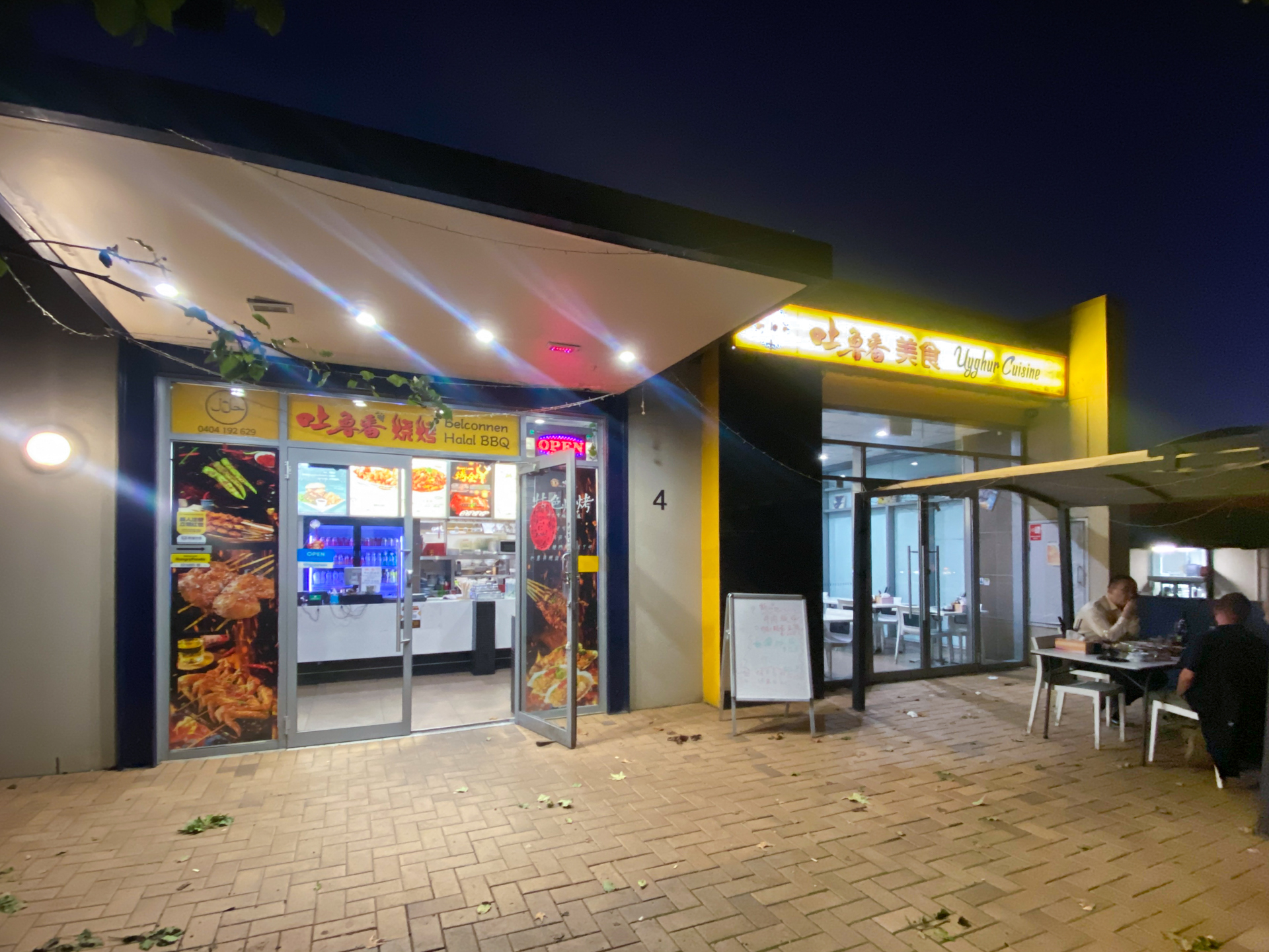 The exterior of a restaurant lit up at night.