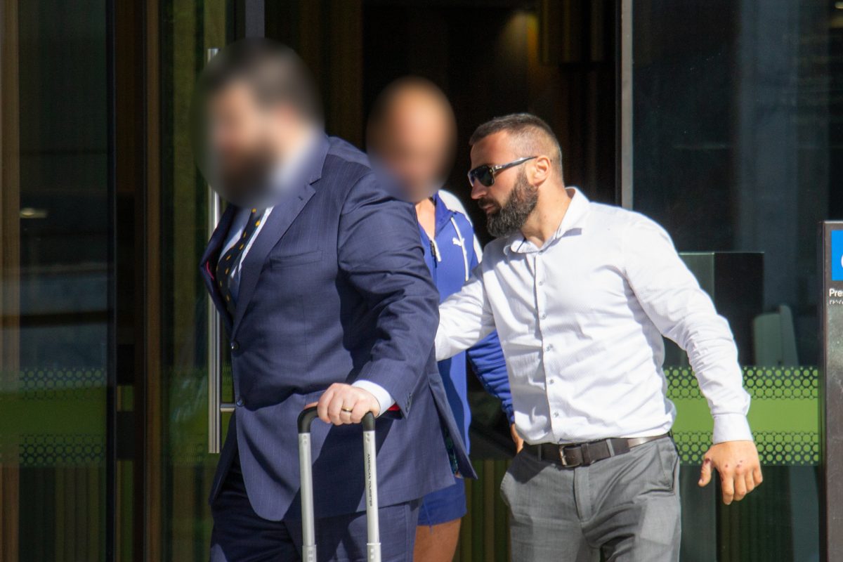 Three people leaving court, two with their faces blurred