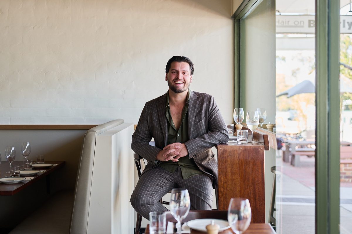 A man sitting in a chair in a restaurant looking at the camera.