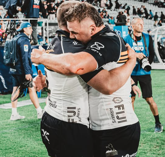 two rugby players hugging after a game