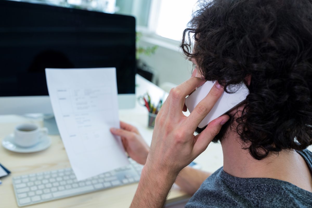 Business executive holding document at his desk