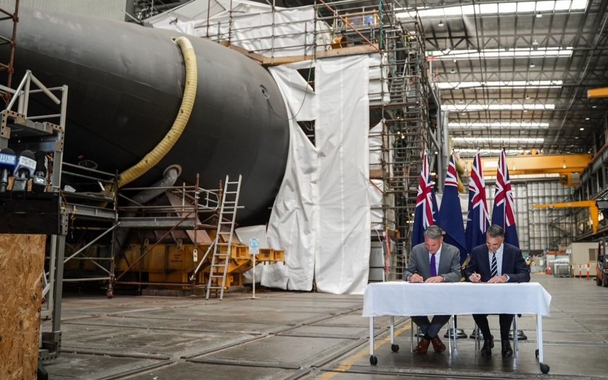 Defence Minister Richard Marles and SA Premier Peter Malinauskas sign an agreement in a defence facility