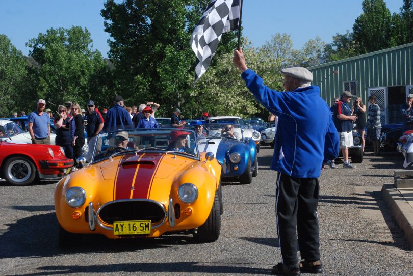 Keith Montague (deceased), one of the founding member of Cooma Car Club waves off a rally. Photo: Cooma Car Club.