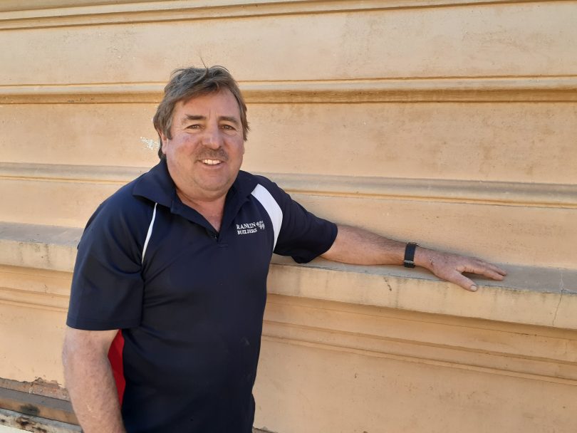 Builder Neil Rankin leaning on wall outside Hotel Australasia.