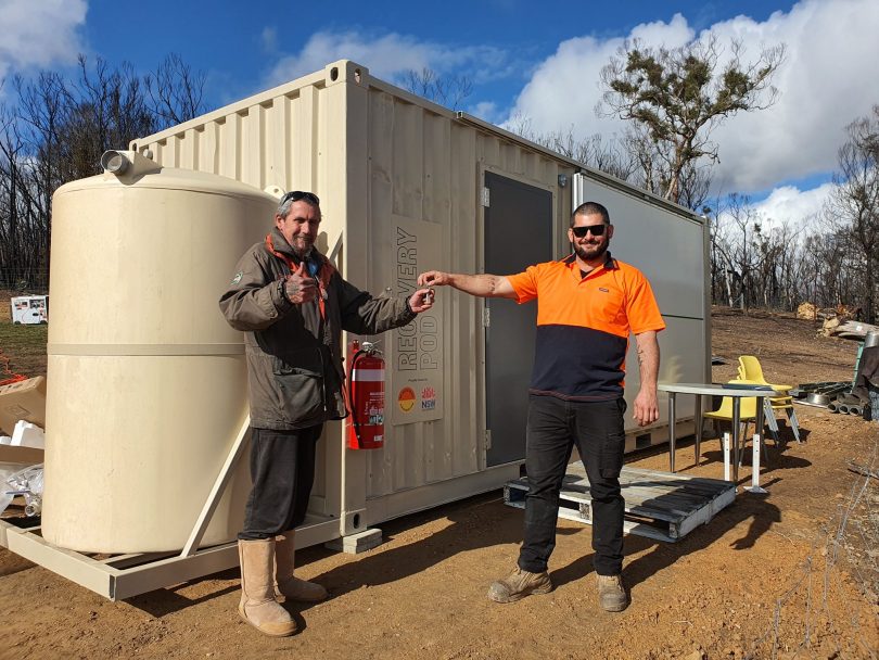 The keys to a recovery pod being handed over to a member of the Nerriga community whose home was destroyed by bushfire.