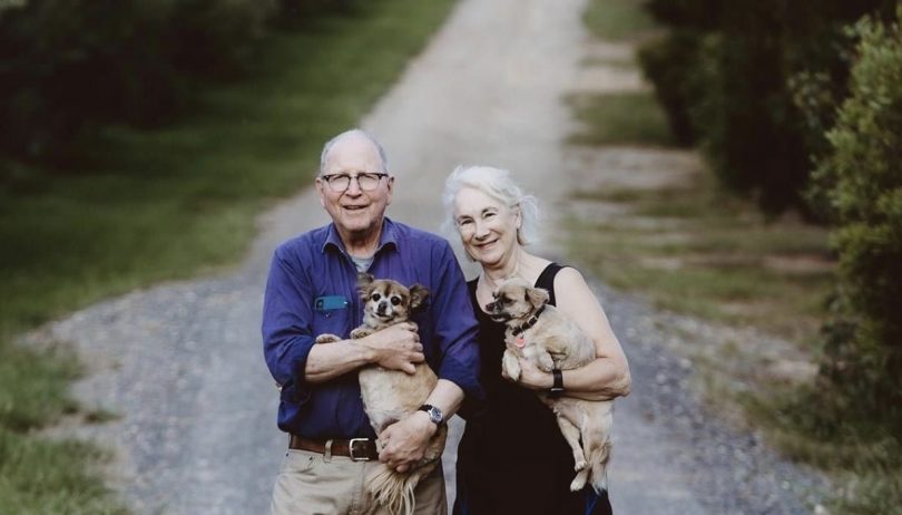 Charley Barber (left) and Rosemary Howe (right) standing on rural track holding dogs.