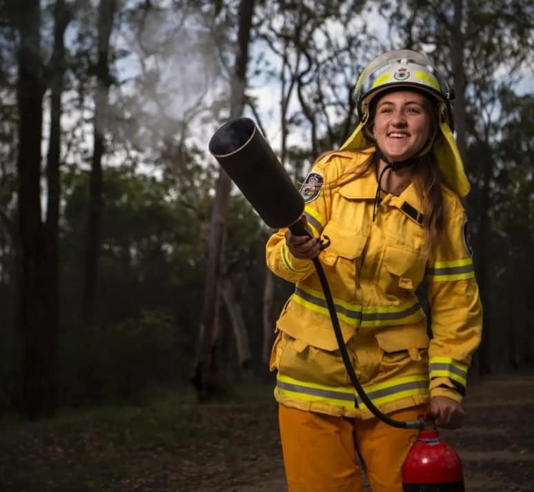 Young girl using fire extinguisher.