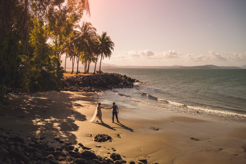 Jayde Theodore and Harri Colbert holding hands on beach.