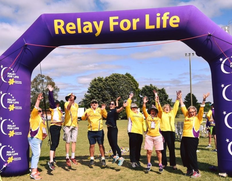 Participants leaping into air during Relay For Life event.