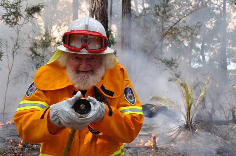 Terry McGee holding hose during bushfire.