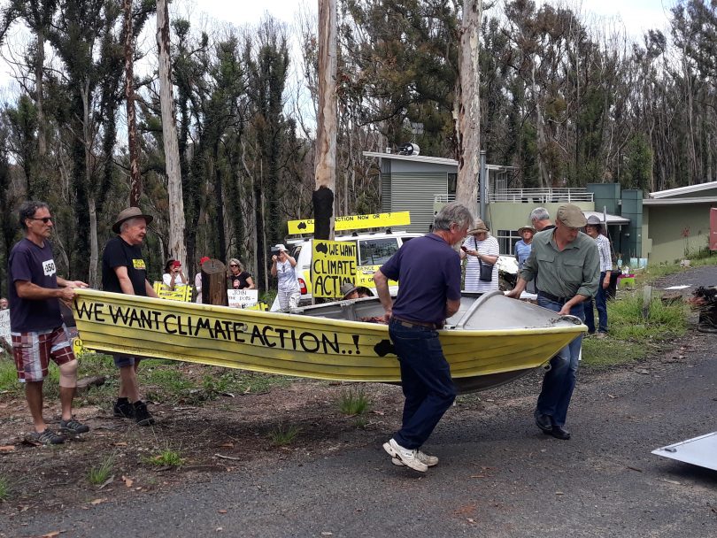 Men lifting tinnie boat onto trailer