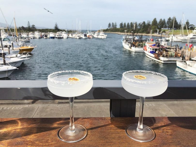 Two cocktails on bar in front of water in Bermagui.