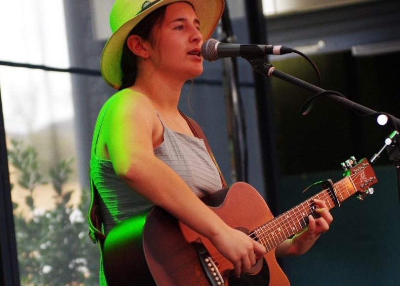 Felicity Dowd performing with guitar onstage.