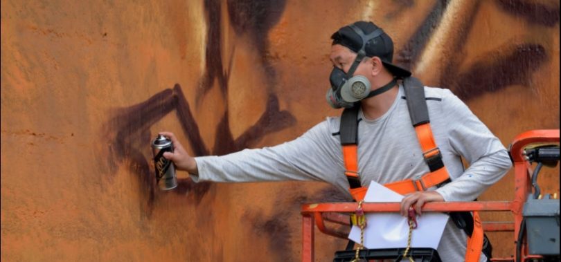 Artist Heesco working on mural on old flour mill silos at Harden-Murrumburrah.