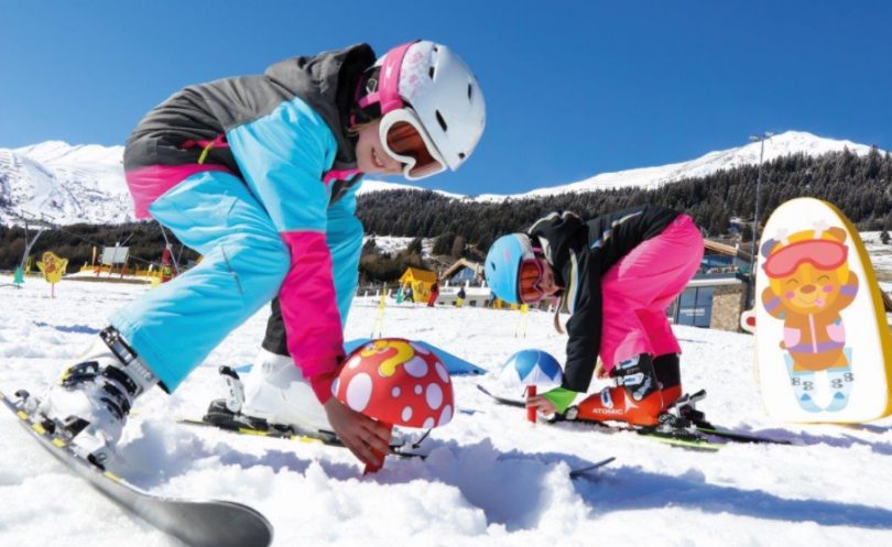 Kids on skis playing in snow.