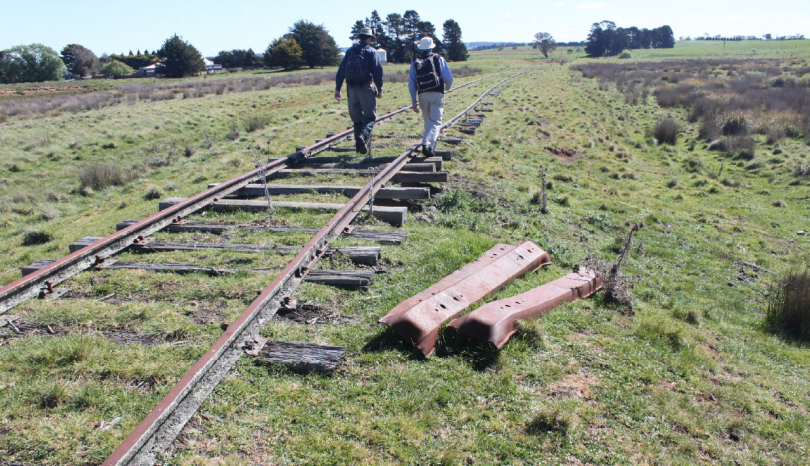 Two men walking along rural non-operational railway line