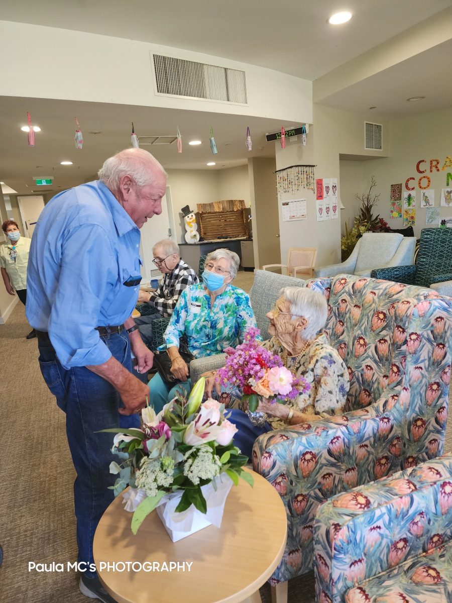 Two old women with old man standing