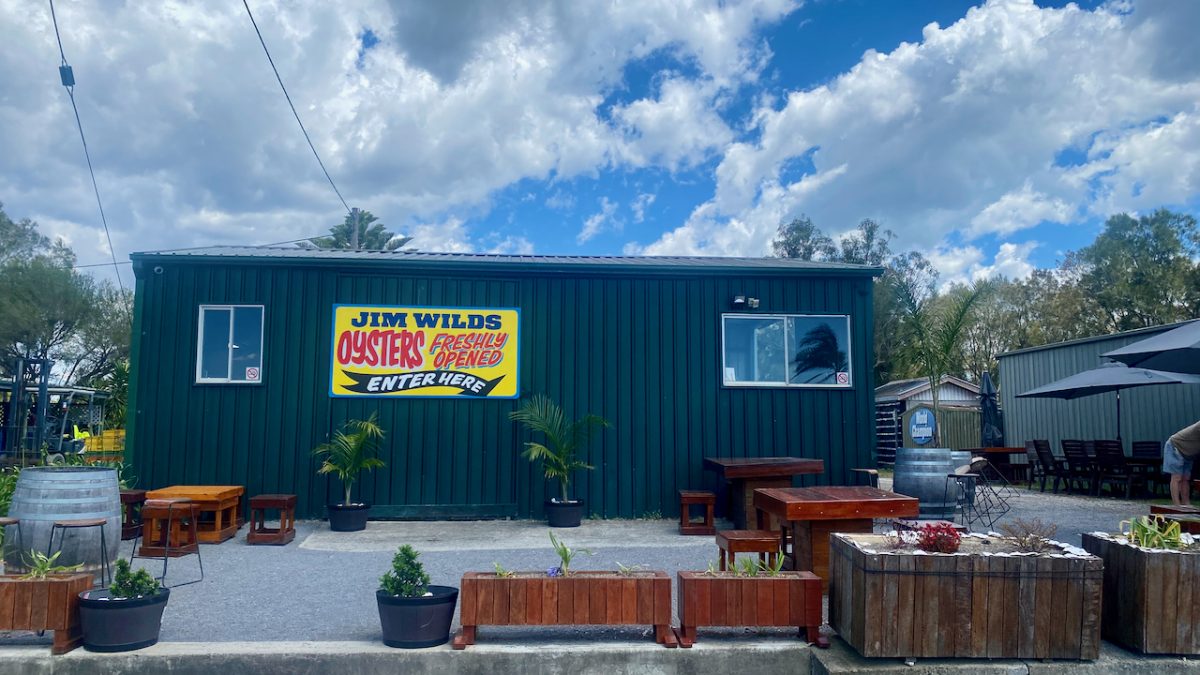 A green shed with sign reading "Jim Wild's Oysters Freshly Shucked, welcome"