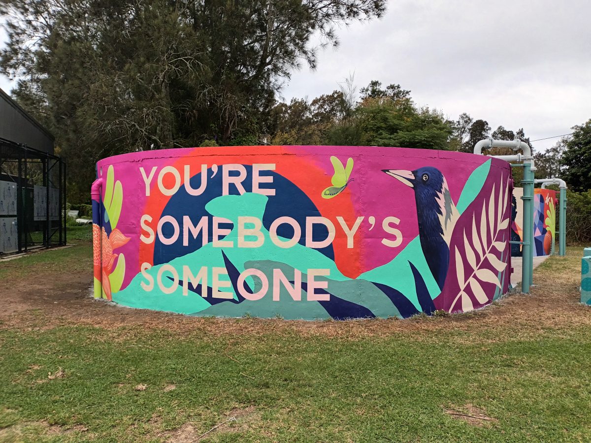 Mural on water tank saying You're Somebody's Someone. 