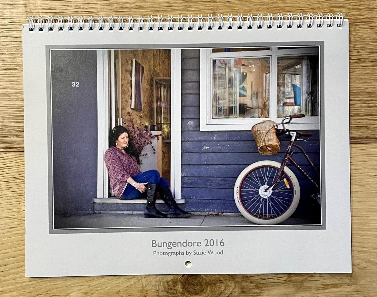 Woman sitting on verandah of blue house near bicycle