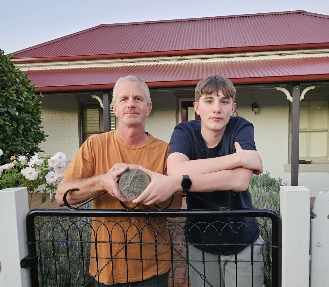 father, son and an old war medallion found in their backyard