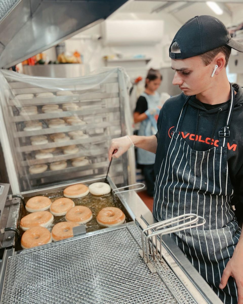 A young man drying donuts