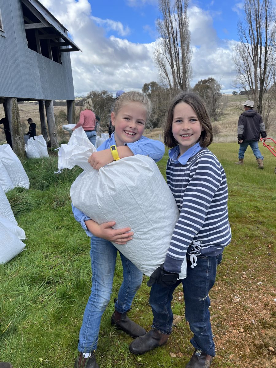 Two little girls holding up big sack