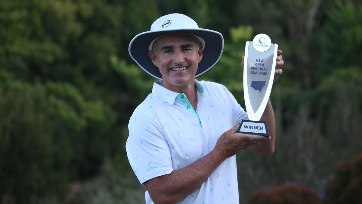 Man in hat holding trophy