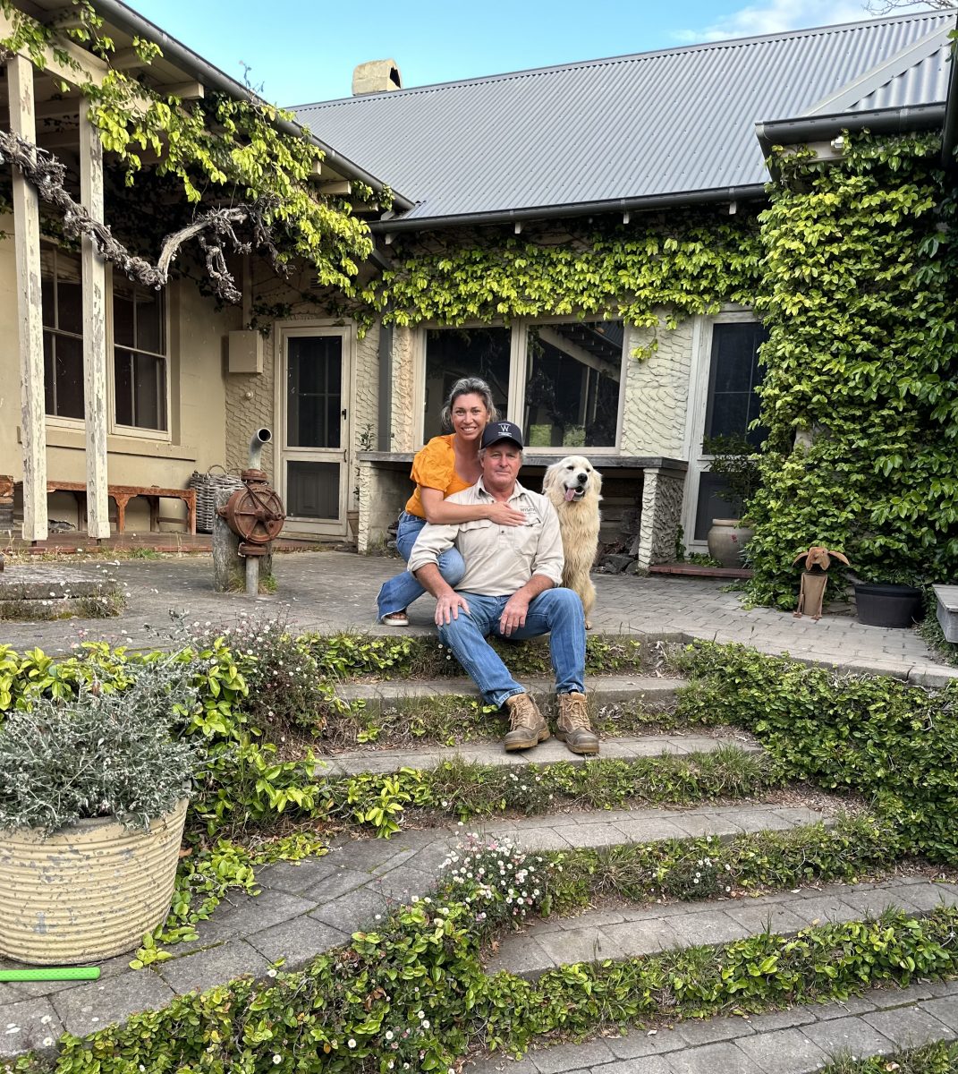 Couple sitting on steps of homestead