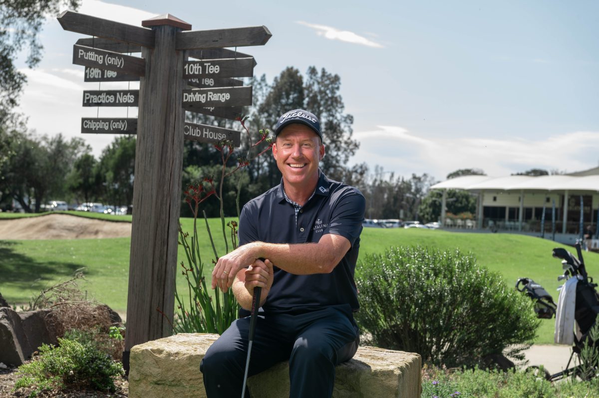 Man sitting on a bench and holding a golf club