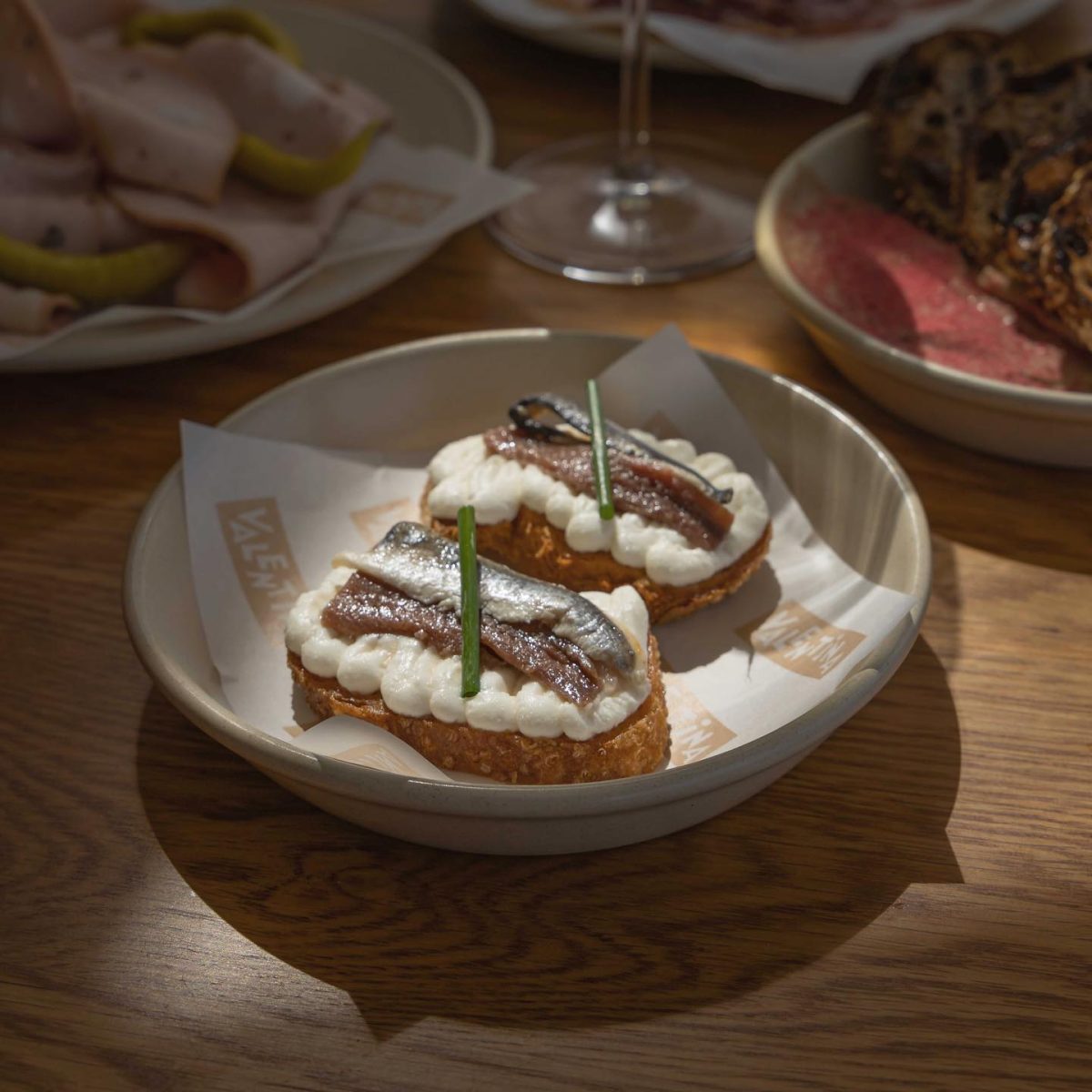 Two pieces of anchovy crostini with whipped ricotta