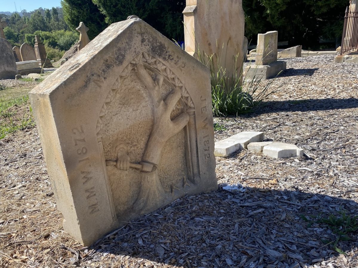 A tree symbolising life is cut down in this poignant footstone facing the headstone of the family grave of John and Marcella Warn and their three little children at Mortis Street Cemetery, Goulburn. 