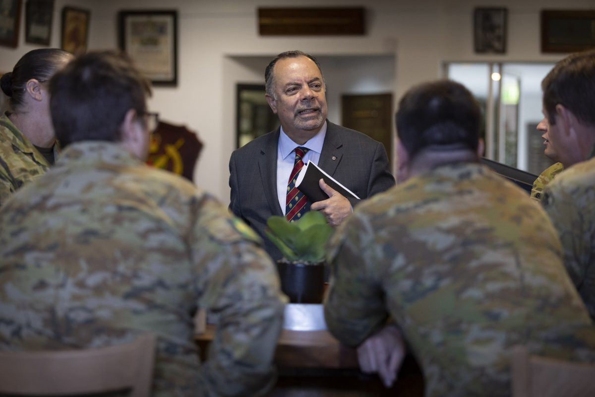 man in suit visiting soldiers