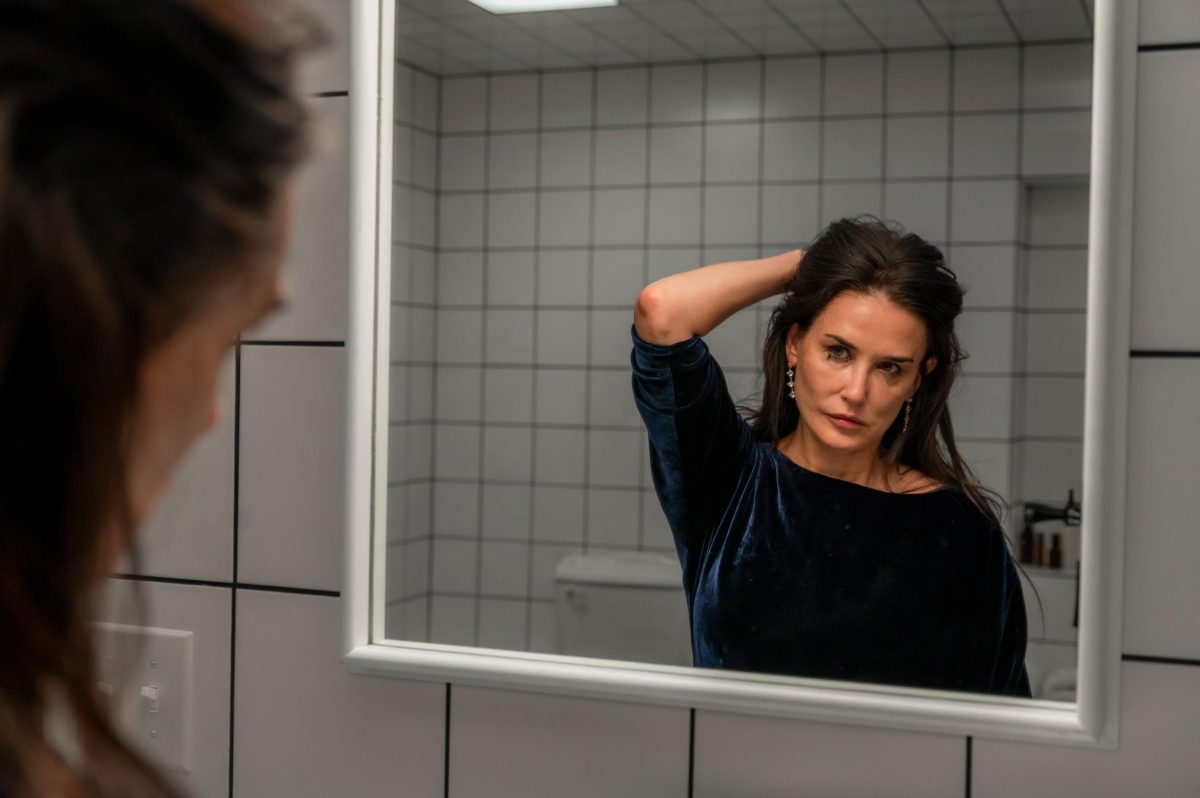 a movie scene in which a woman is looking into a bathroom mirror